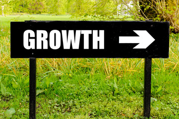 GROWTH written on directional black metal sign