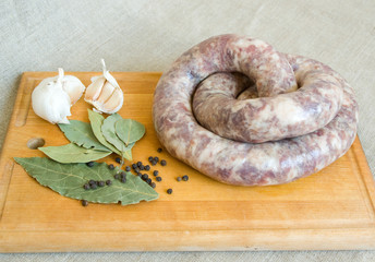 Uncooked homemade sausage with bay leaves, garlic, pepper