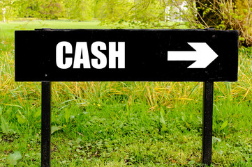CASH written on directional black metal sign