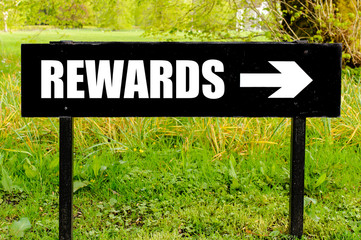 REWARDS written on directional black metal sign
