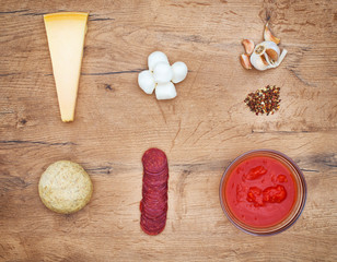 Food ingredients for pizza on wooden tabletop. Top view.