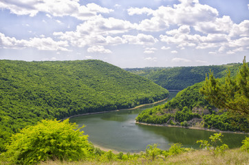 Obraz premium River between green hills with the blue sky