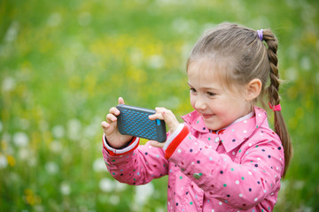 Little girl photographing with her smartphone