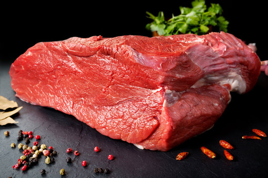 Carne fresca y cruda. Pieza entera de carne roja lista para cocinar a la parrilla o barbacoa. Fondo negro pizarra
