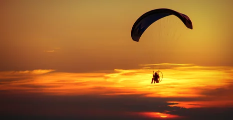 Foto auf Acrylglas Luftsport Mann genießt Gleitschirmfliegen am Himmel