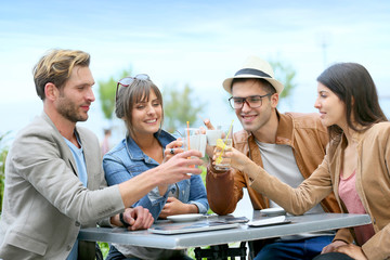 Group of friends cheering at restaurant terrace