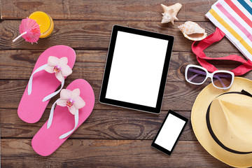 Blank empty tablet computer, summer accessories on beach. 
