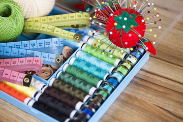 Sewing kit. Colored thread, pins, buttons, ribbons, safety pin.