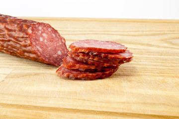 salami sausages on wooden board isolated