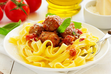 Egg tagliatelle with meatballs in tomato sauce.