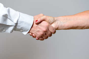 Zwei Erwachsene geben sich die Hand
