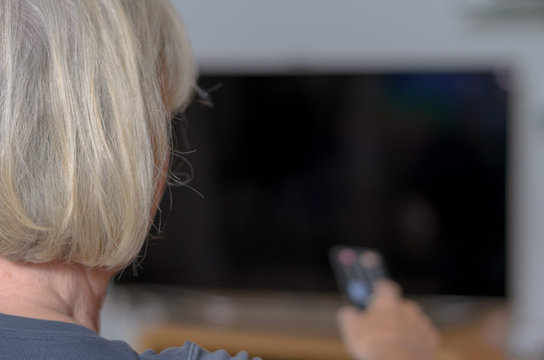 Frau h&auml;lt eine Fernbedienung