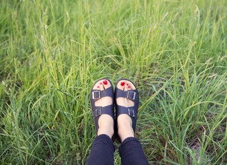 Woman  feet on green grass background