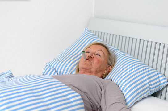 Kranke Frau mit Fieber im Bett