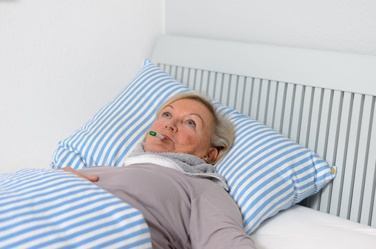 Kranke Frau mit Fieber im Bett