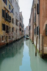 Fototapeta na wymiar Narrow channel with gondol in san Marco, Venice, Italy