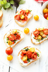 Tasty fresh bruschetta with tomatoes on white wooden background