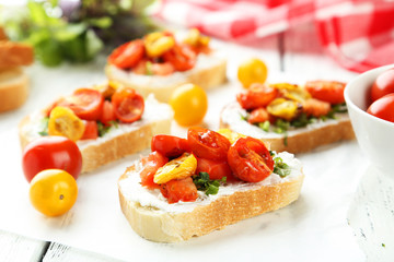 Fototapeta na wymiar Tasty fresh bruschetta with tomatoes on white wooden background