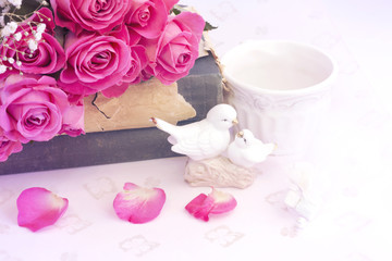 figurines wedding doves in love Valentine bouquet of pink roses on old books floral background is love tenderness vintage retro selective soft focus