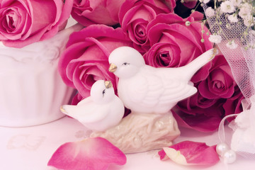 figurines wedding doves in love Valentine bouquet of pink roses on old books floral background is love tenderness vintage retro selective soft focus