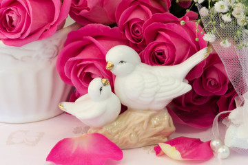 figurines wedding doves in love Valentine bouquet of pink roses on old books floral background is love tenderness vintage retro selective soft focus