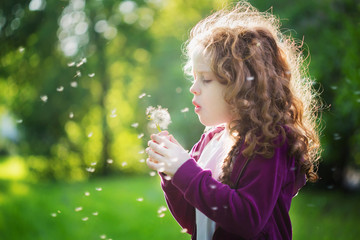 Child with white dandelion in your hand. Background toning insta