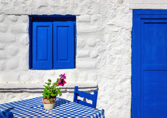 Iconic blue table with wooden chairs , Greece - 84398943