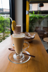A cup of hot cappuccino with Chocolate banana smoothie and bread