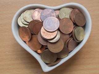 Baht coins in the heart shape cup.