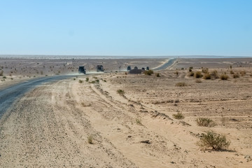 Convoy of 4x4 vehicle drive a dusty desert track in Tunisa