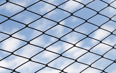 metal fence against the blue sky with clouds