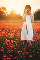 Girl taking picture on poppy field