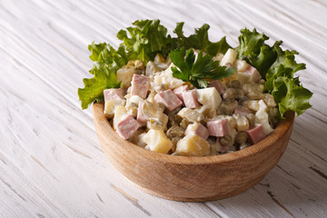 Russian salad close up in a wooden plate