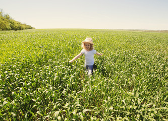 Little blonde girl in a wheat field, summer outdoor