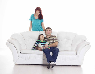 Father, mother and their son sitting on the sofa