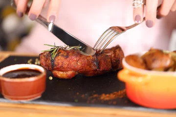 Photo sur Plexiglas Steakhouse woman eating steak in a restaurant