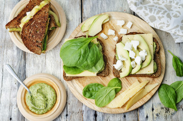 grilled rye sandwiches with cheese, spinach, pesto, avocado and