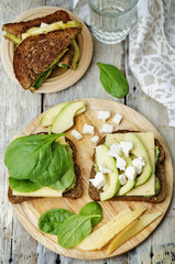 grilled rye sandwiches with cheese, spinach, pesto, avocado and