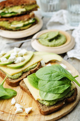 grilled rye sandwiches with cheese, spinach, pesto, avocado and