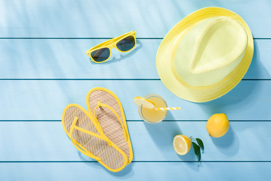 Summer accessories on blue wooden background top view