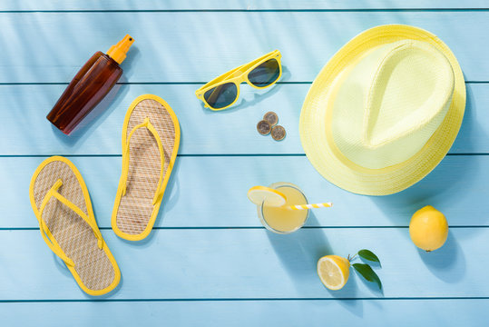 Summer accessories on blue wooden background top view