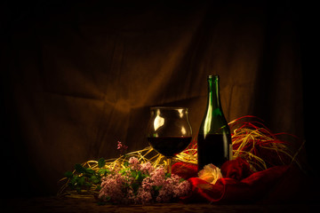 Glass and Bottle of Red Wine in Elegant Setting