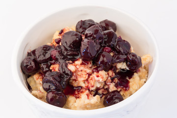 breakfast oatmeal with cherry jam in a white ceramic bowl shabby chic retro vintage health diet selective soft focus