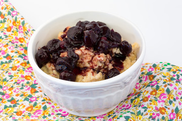 breakfast oatmeal with cherry jam in a white ceramic bowl shabby chic retro vintage health diet selective soft focus