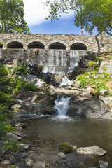 Fototapeta na wymiar Stone bridge at Highland Park Falls in Manchester, Connecticut.