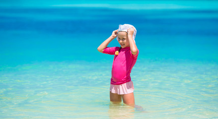 Adorable happy little girl have fun at shallow water on beach