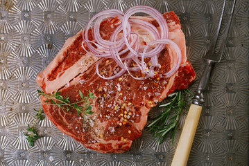 beef steak t-bone with vintage meat fork on metal backdrop