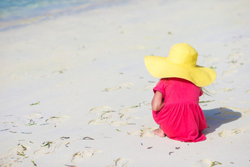 Adorable little girl in hat at beach during summer vacation