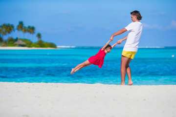 Little cute girl and dad during tropical beach vacation