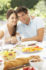 Obraz na płótnie Canvas Young Couple Enjoying Meal Outdoors